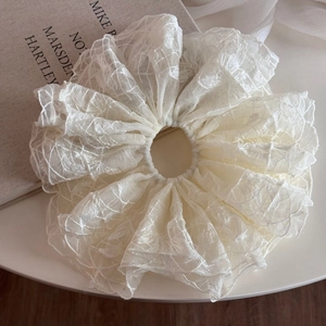 Vue détaillée du chouchou géant en dentelle crème montrant la texture maille et les plis