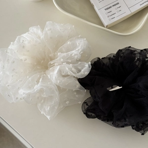 Detail of black and white tulle scrunchies with velvet polka dots and wavy edges