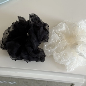 Detailed texture of black and beige organza scrunchies with delicate flocked dots