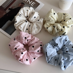 Vue détaillée de quatre chouchous à pois colorés avec étiquette mode sur fond blanc