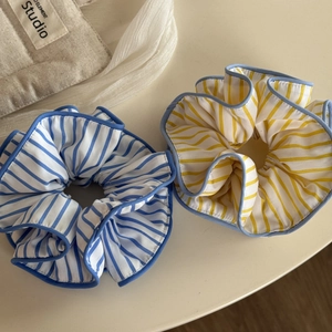 Détail des chouchous en tissu à rayures bleues et jaunes durables avec couture de bord fine