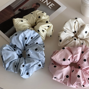 Détails de grands chouchous à pois en tissu bleu clair, rose, crème et blanc soyeux