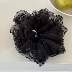 Detail of black mesh hair scrunchie featuring 3D flocked polka dots and soft fabric texture