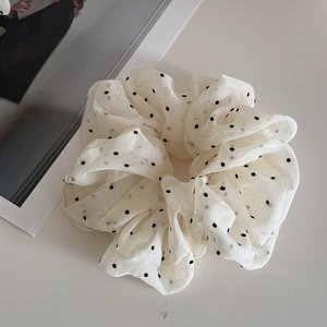 Detail shot of oversized polka dot organza scrunchie with soft tulle texture and volume