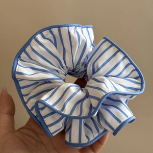 Gros plan d'un chouchou oversize à rayures bleues et blanches avec liseré contrasté