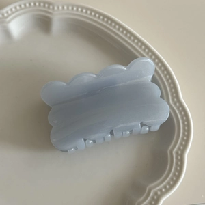 Detail einer hellblauen Haarklammer aus Acetat mit Wellenrand und Marmorstruktur