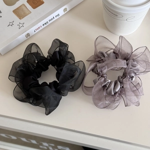 Detail von eleganten Satin-Haargummis in Schwarz und Grauviolett mit Lagen-Design