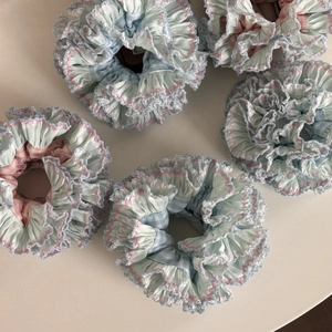 Blue and pink plaid scrunchie hair ties with ruffled edges and soft fabric texture
