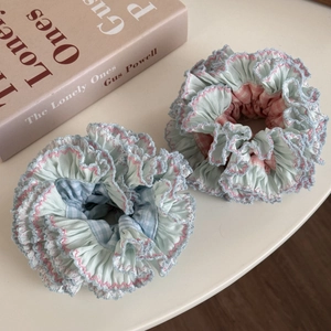 Detailed macro view of pastel blue and pink checkered scrunchies on a vintage book