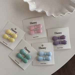 Five pairs of mini bow hair clips in pastel macaron colors on display cards