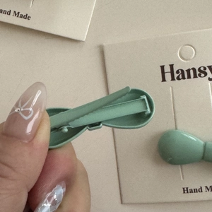 Detail view of mini matte bow hair clips with metal duckbill clips on a backing card