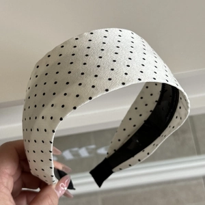 Detailed close-up of wide cream headband with black polka dots and anti-slip lining