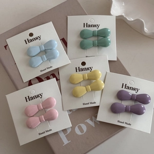 Mini resin bow hair clip set in five pastel colors including mint and yellow on display card