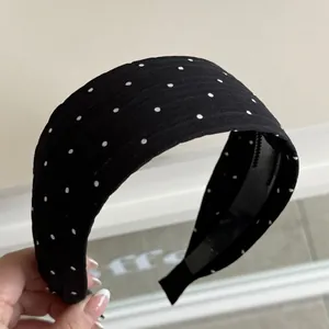 Detailed view of black and white polka dot wide headband with non-slip inner teeth