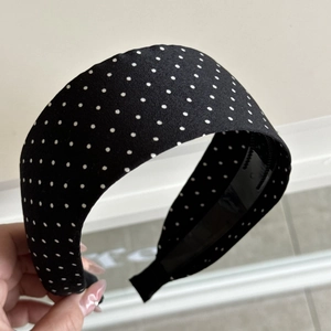 Detail shot of wide black and white polka dot headband featuring retro fabric texture