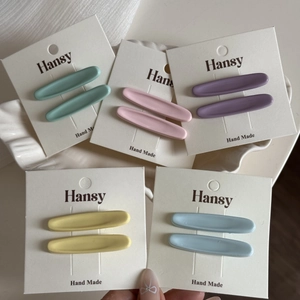 Dettaglio dei fermagli per capelli opachi color macaron su un piatto decorativo bianco