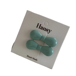 Pair of mint green resin bow hair clips on white card for women hair accessories