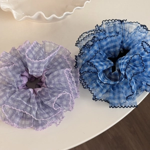 Close-up of blue and purple plaid organza scrunchies with wavy ruffles and soft mesh texture