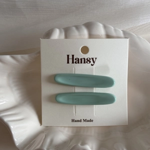 Dettaglio di fermagli per capelli verde menta su un vassoio decorativo in ceramica
