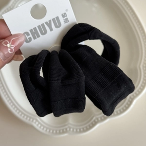 Vue détaillée d'un chouchou noir hautement élastique avec texture côtelée sur assiette