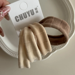 Détail de quatre élastiques à cheveux en soie glacée aux tons dégradés de marron