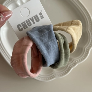 Détail de quatre élastiques à cheveux nervurés pastel en rose, bleu, vert et beige