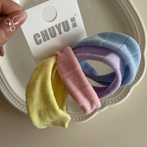 Gros plan détaillé de quatre élastiques à cheveux en soie glacée aux couleurs pastel