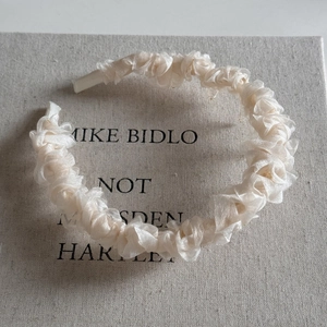 Détail du serre-tête en résille blanche avec textures plissées en organza multicouches