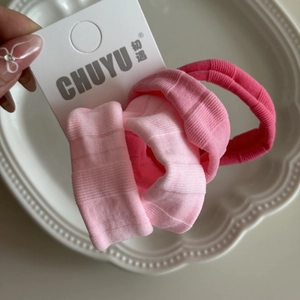 Gros plan sur des chouchous élastiques roses avec une texture de tissu côtelé