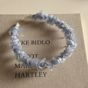 Détail d'un serre-tête plissé bleu clair en maille avec texture douce en organza