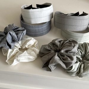 Detailed view of striped scrunchies and headbands in cream, grey, and green fabrics
