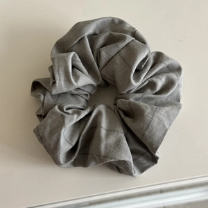Macro shot of gray plaid scrunchie hair tie showing detailed cotton fabric texture