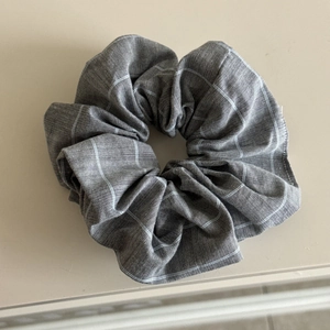 Close-up detail of grey checkered scrunchie with soft cotton blend fabric texture