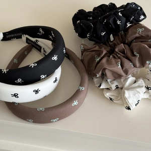 Détail de chouchous et de bandeaux en tissu avec motif à nœuds en noir, blanc et marron