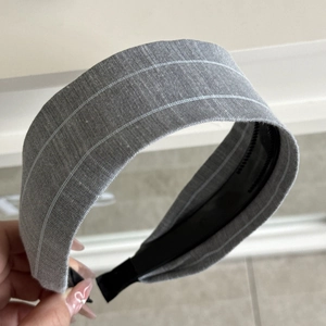 Detail of grey striped fabric hair scrunchie with soft texture and internal non-slip base