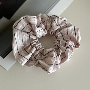 Macro detail of pink striped high-count cotton hair scrunchie with soft pleated texture
