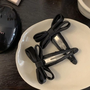 Elegant large black satin ribbon bow hair clips set in a minimalist silk texture design