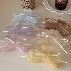 Detailed view of large ballet style hair claws with silk ribbons in assorted pastel colors