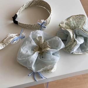 Detail van lichtblauwe bloemen haarelastiek en hoofdband set met kanten rand