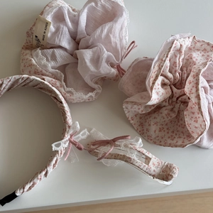 Detail van bloemen haaraccessoires set met kanten rand op een wit oppervlak