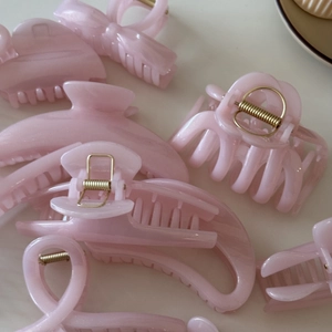 Detail view of pink jelly hair claws with fine glitter in heart and bow shapes
