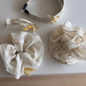 Detailoverzicht van de 4-delige haaraccessoireset met gele bloemenprint op chiffon stof