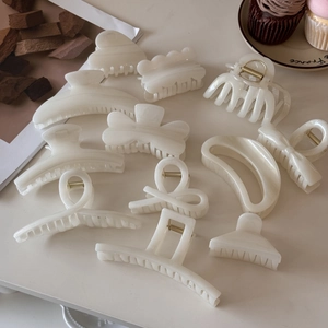 Detailed set of cream white jelly hair claws in various shapes with pearlescent finish