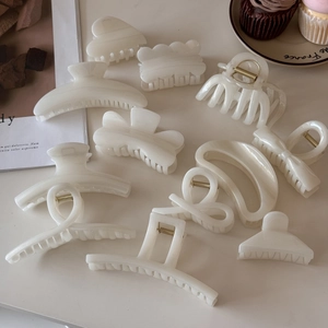 Detailed set of cream white hair claw clips in various shapes with a smooth finish