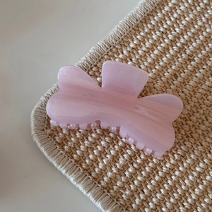 Detail of pink glitter butterfly hair claw clip with pearlescent resin finish and metal spring