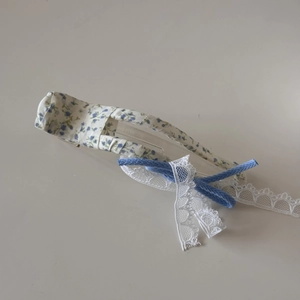 Detail van florale scrunchie met blauwe strik en wit kant voor haarstyling