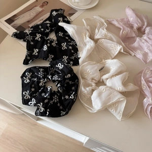 Detailed view of chiffon scrunchies with white bow embroidery in black, white and pink colors