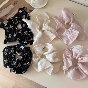 Detailed close-up of chiffon bow scrunchies with elegant snowflake embroidery details