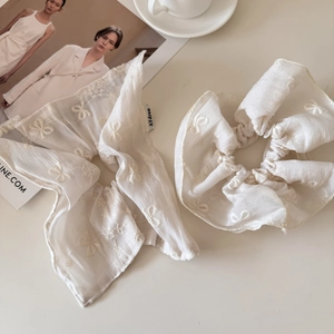 Macro shot of white organza scrunchie and bow set with elegant butterfly embroidery