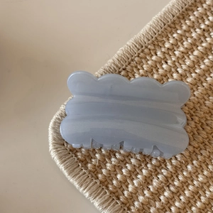 Macro shot of hazy blue wavy edge hair claw clip with pearlescent marble texture